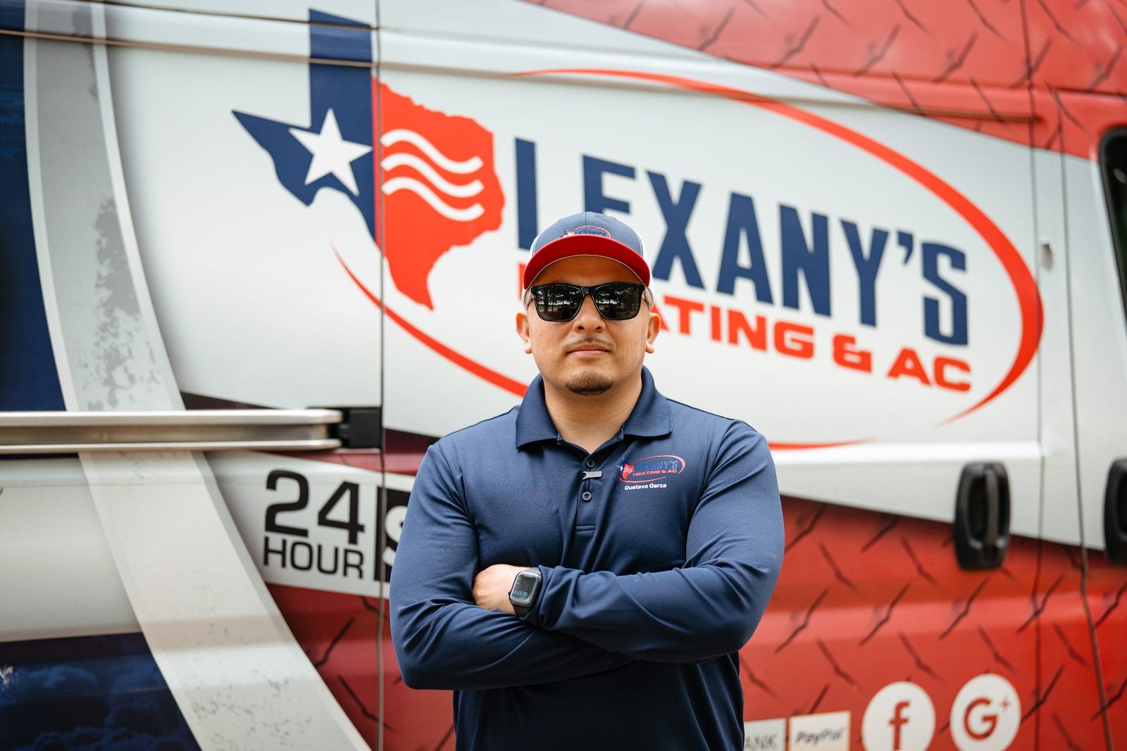 A Lexany's Heating & AC technician in uniform by the company service van in Forney, TX