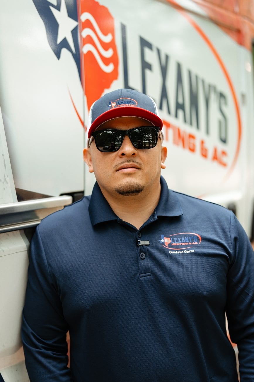 Gustavo Garza, owner of Lexany's Heating & AC, by the company service van in Forney, TX