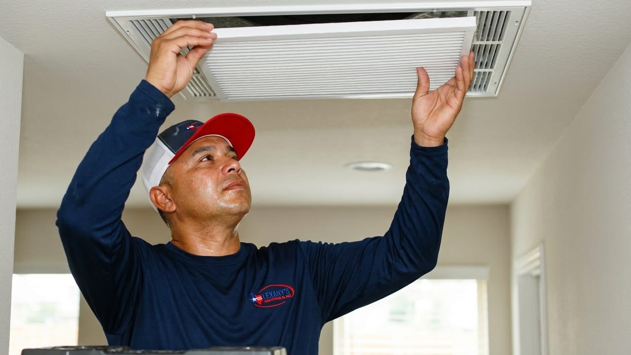Lexany's Heating & AC technician replacing a clean air filter in a return-air grille in a Forney, TX home